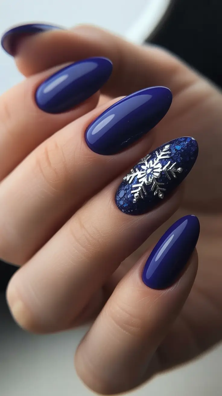 almond winter 2025 / 2026 nails design and color - Midnight Comet - Navy Almond With 3D Snowflake Accent