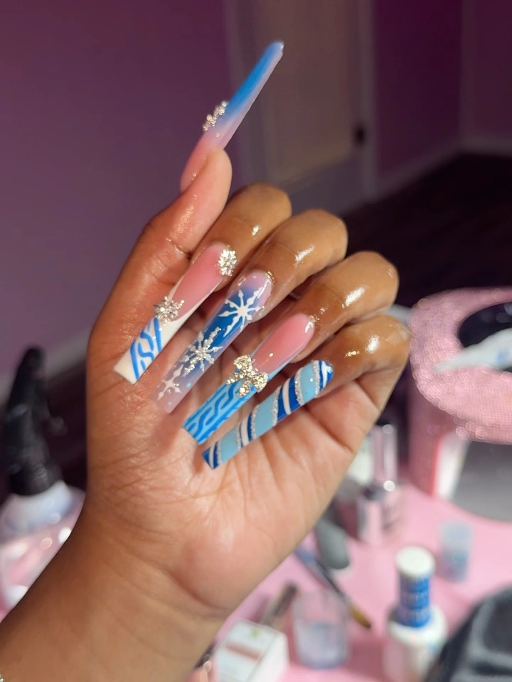 Long coffin nails with blue stripes, white snowflake, and sparkling accents