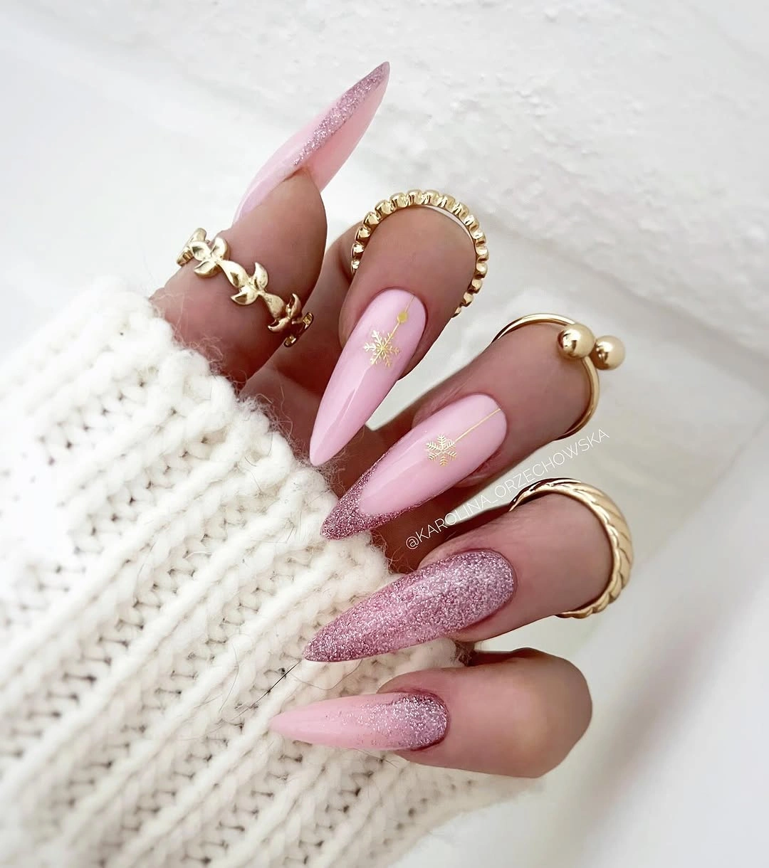 Long pink pointed nails with rose glitter and gold winter motifs