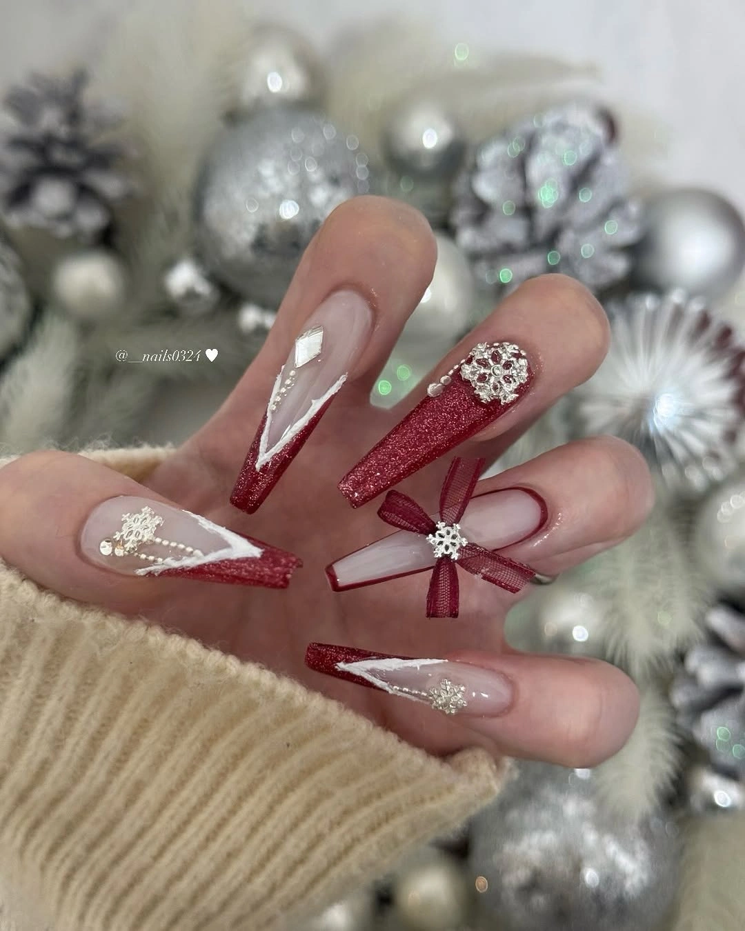 Long square nails with red glitter tips, white snowflakes and ribbon design