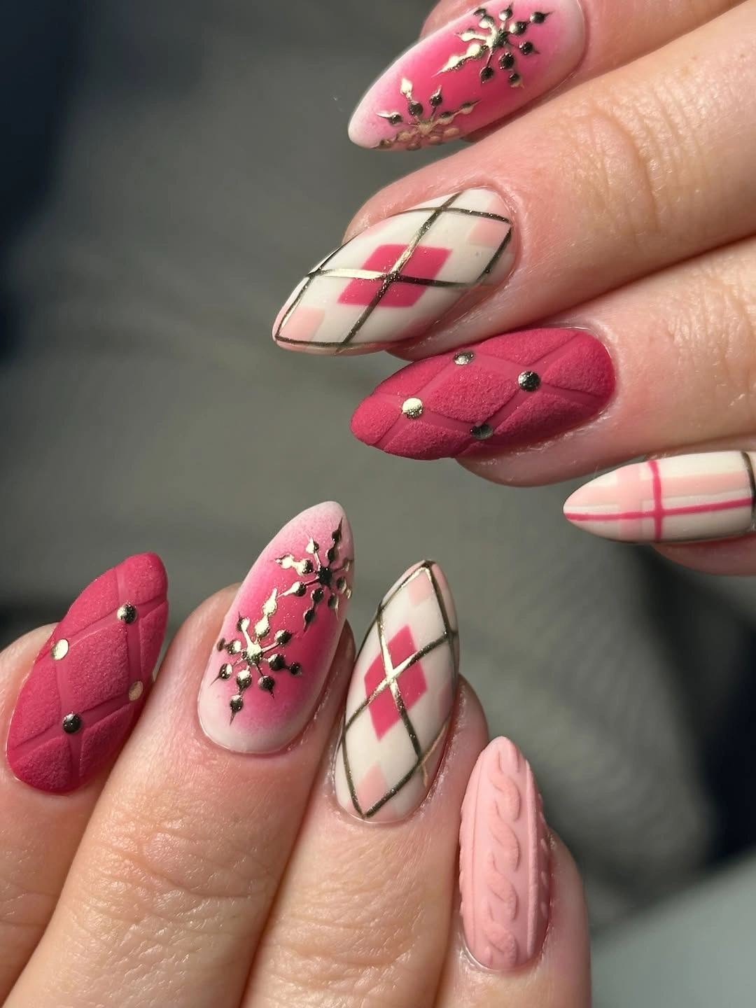Pink almond nails with argyle patterns, raised knit textures and branching accents